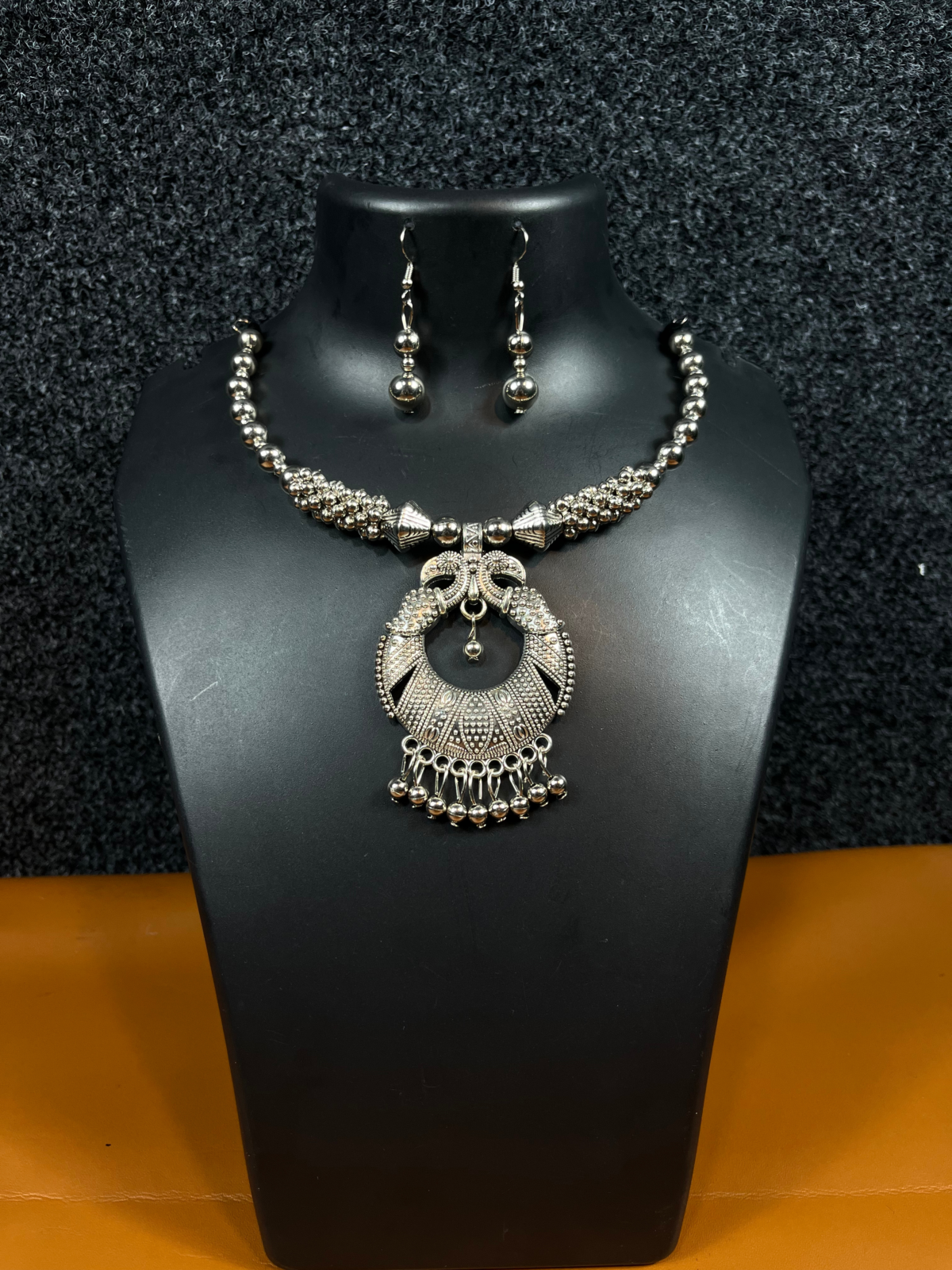 Oxidized silver Chandbali necklace set with matching drop earrings displayed on a black mannequin – perfect for ethnic wear and festive occasions.