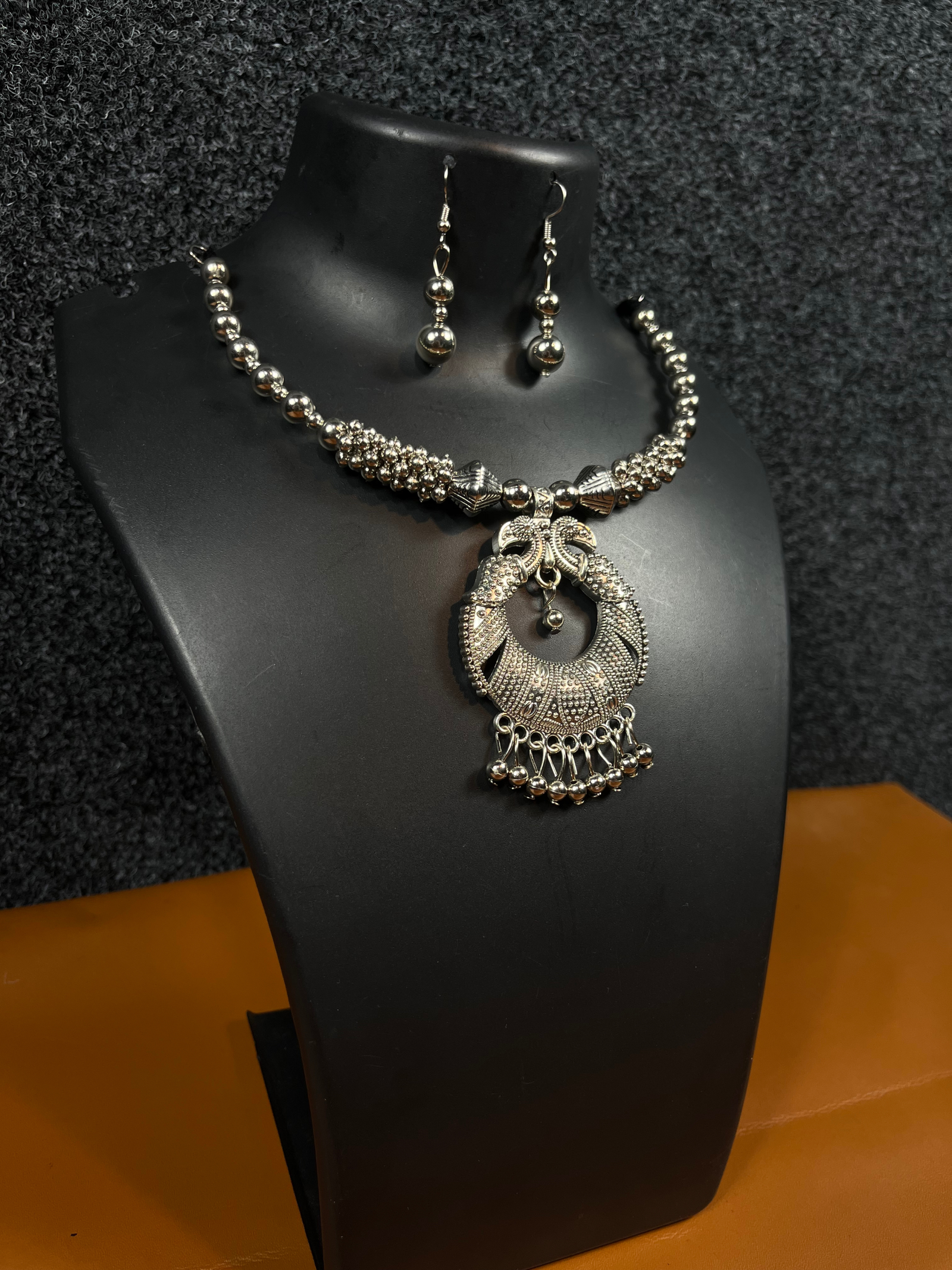 Oxidized silver Chandbali necklace set with matching drop earrings displayed on a black mannequin – perfect for ethnic wear and festive occasions.